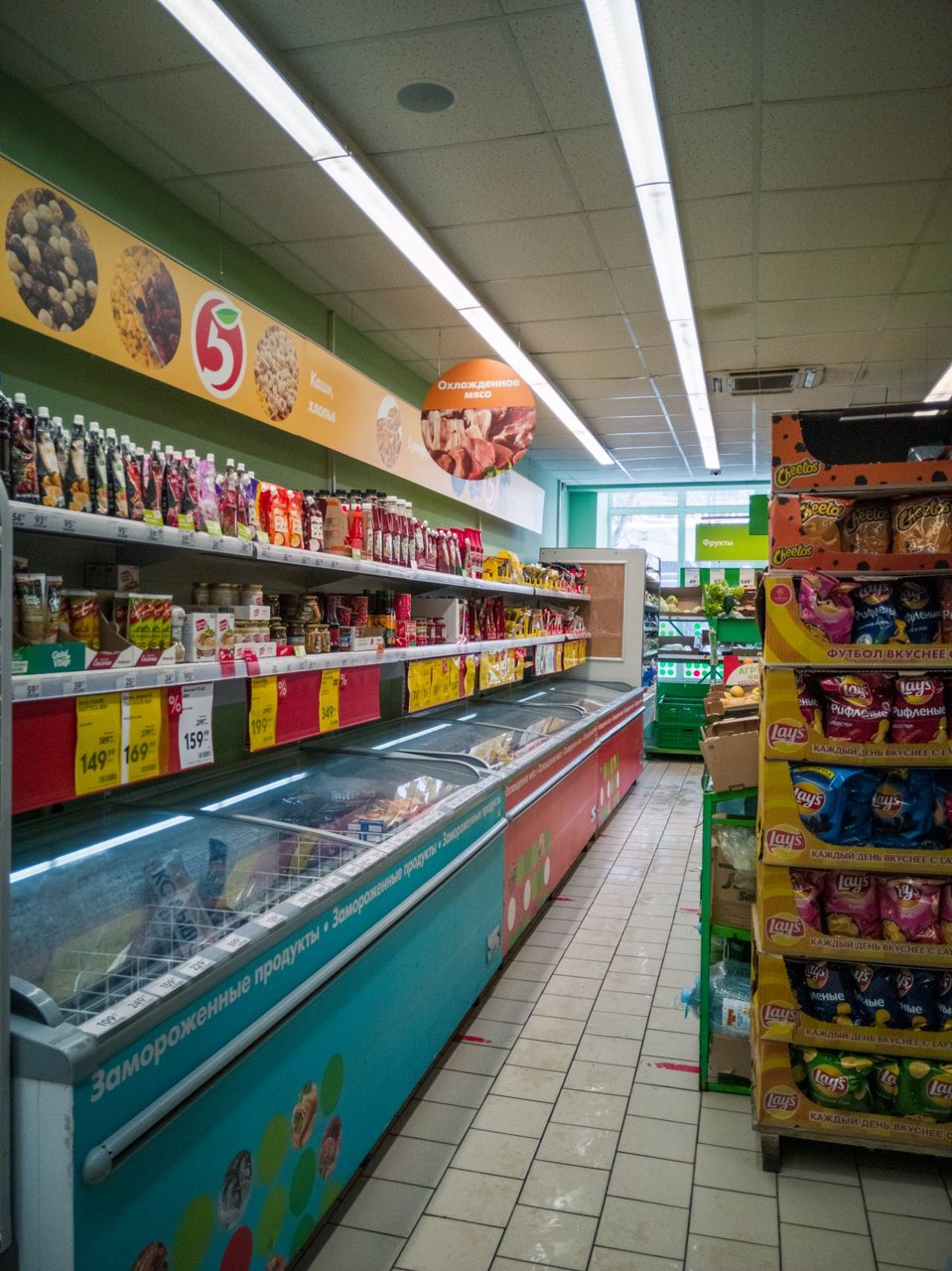 Free Explore a well-stocked aisle in a Russian supermarket. Frozen goods and snacks line the shelves. Stock Photo